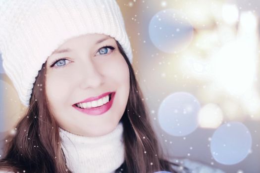 Christmas, people and winter holiday concept. Happy smiling woman wearing white knitted hat as closeup face xmas portrait, snow glitter and bokeh effect.