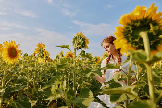 woman with two pigtails in a white dress admires nature flowering plants. High quality photo