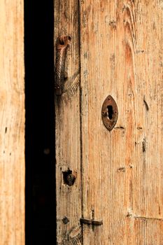 Forged metal vintage door knocker on brown wooden door in Beniarda, Alicante, Spain