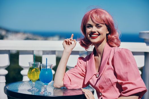 smiling woman in pink with pink hair vintage alcohol cocktails restaurant. High quality photo