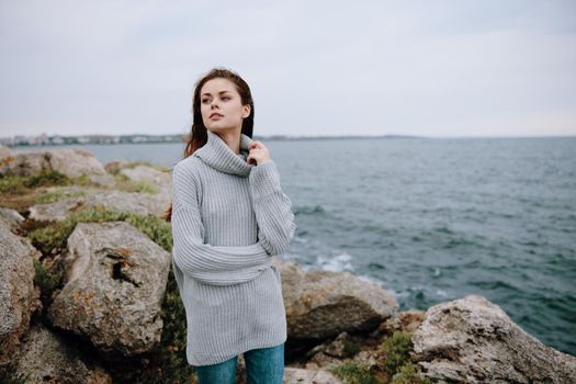 woman sweaters cloudy sea admiring nature Relaxation concept. High quality photo