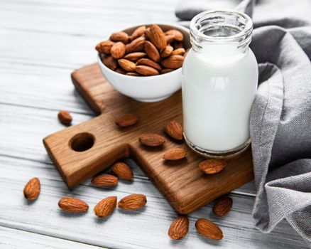 Almond milk with almonds on a wooden table