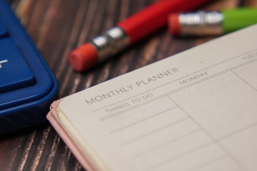 close up of weekly planner and notepad on table .