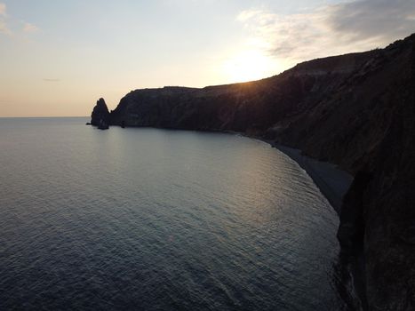 Aerial panoramic view of beautiful sunset above sea. Beautiful seascape. Sun glare, small waves on the water surface. Evening. Horizon. Nobody. No people. Copy space. Never-ending beauty of nature