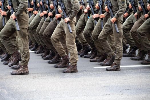 Selective focus. Motion blur. Modern military footwear on soldiers. A soldier in uniform is marching in the parade. People in the crowd. Boots on the foot.