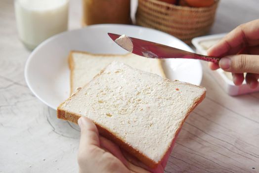 butter spreading on a bread close up .