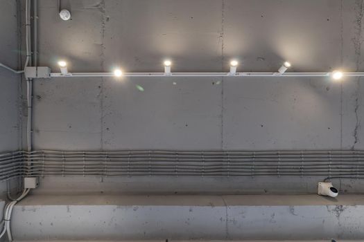 Interior architecture and ceiling design of industrial loft building decorated with modern lamps, glass windows and wall speakers