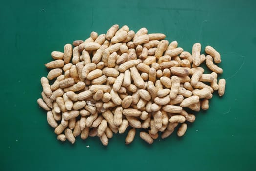 many peanuts on a green background top view ,