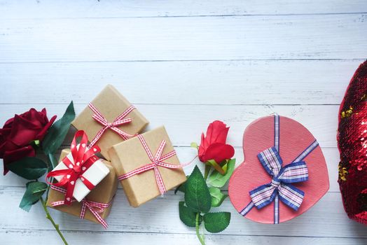 Top view of gift box and rose flower on color background .
