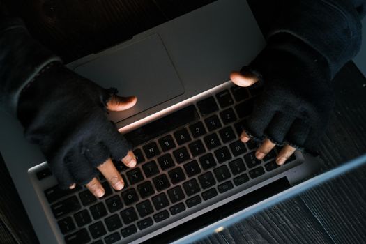 hacker hand stealing data from laptop top down.