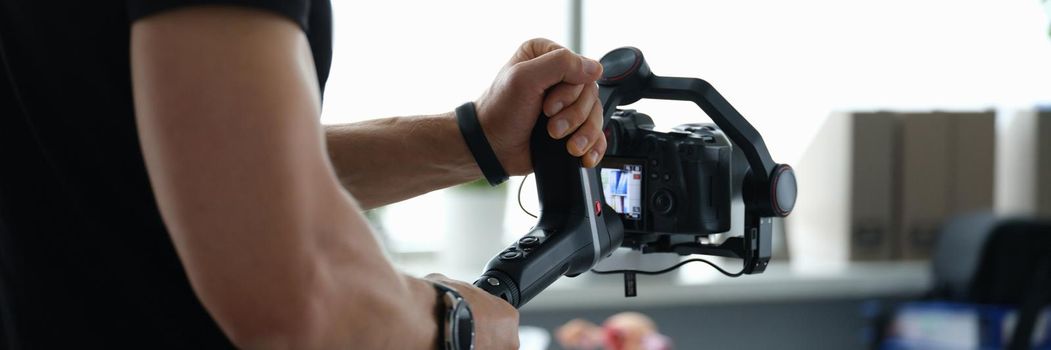 Videographer holds stabilizer with camera in hands. High-quality video shooting concept