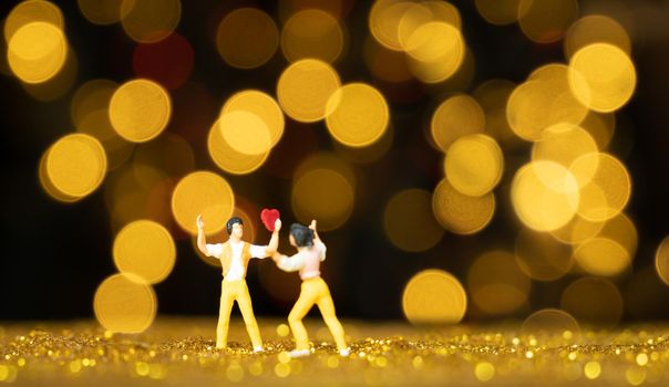 Miniature people man holding red heart for lover with light bokeh background,Valentines concept