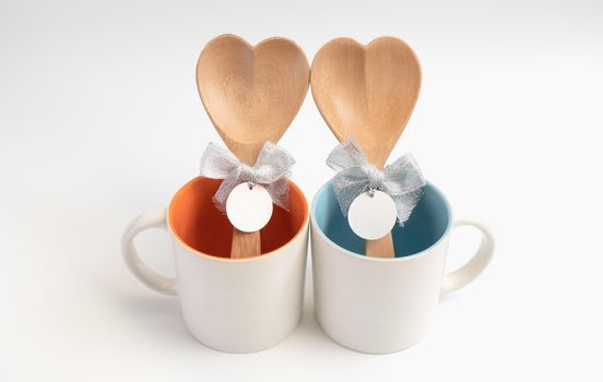 Cup of love,Two coffee cups with wooden spoon in  heart shape on white background