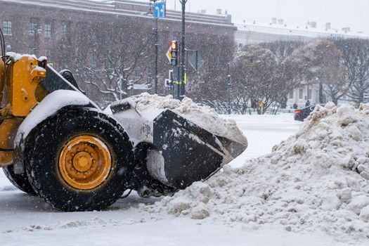 Saint-Petersburg, Russia. - December 04, 2021. Close-up of large-scale snow-plowing equipment taking part in snow removal in historical part of city during heavy snowfall. Selective focus.