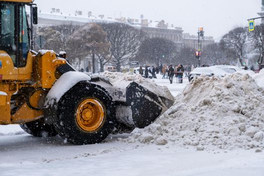 Saint-Petersburg, Russia. - December 04, 2021. Close-up of large-scale snow-plowing equipment taking part in snow removal in historical part of city during heavy snowfall. Selective focus.