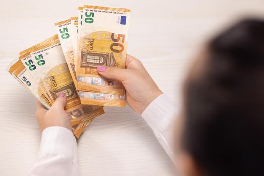 Counting euros. Close-up of Female hands counts a bundle of 50 and 100 Euro banknotes. Successful business. Issuing salary. Cash banknotes. Bribe and corruption concept.