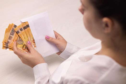 Euro banknotes in white envelope. Businesswoman counting paper currency, great cash income and profit. Financial investment in future, money exchange concept. Cash money calculations.