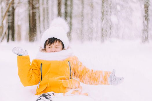 The boy throws snow in winter lifestyle . Winter walks. An article about children's winter leisure. Entertainments