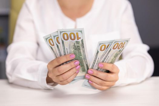 Woman cashier counting one hundred dollar bills. Businesswoman hands recounting american paper currency. Female hands holding 100 dollar banknotes. Save money concept. Dirty money.