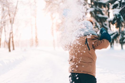 The boy throws snow with a shovel lifestyle . Winter walks. An article about children's winter leisure. Entertainments