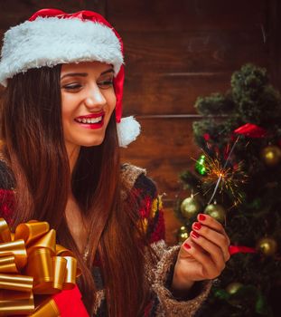 Nice Woman Celebrate New Year has a Sparkler in her Hand. Midnight, Eve, Patty, Tree. Wood Background, Close-up. High quality photo