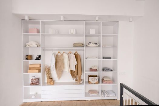 huge built-in open wardrobe with lighting and many sections for women's clothing, lingerie, shoes and accessories. room zoning, dressing area. High quality photo