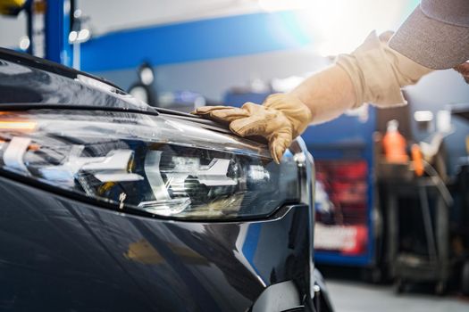 Auto Service Technician Checking on a Car Headlight. Modern LED Vehicle Front Lighting. Automotive Industry and Technology.