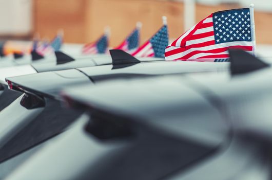 American Cars Dealership. Automotive Industry Theme. Brand New Modern Vehicles with American Flags Attached.