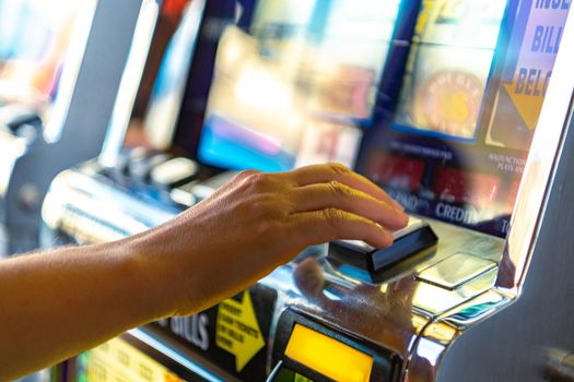 Caucasian Woman Playing Slot Machine Game Close Up Photo. Gambling Industry Theme.