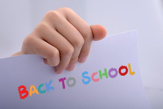 Hand holding a white sheet of paper on a white background