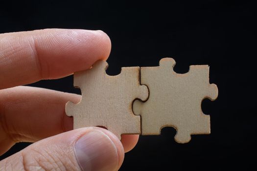 man holding last piece of jigsaw puzzle as business strategy concept