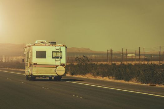 RV Road Trip. Vintage Aged Camper Van on a Highway. Recreational Vehicles Theme.