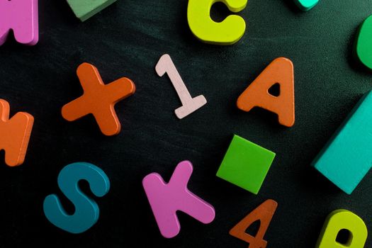 Wooden numbers, letters and blocks on a black background