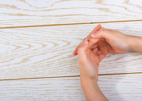 Hands making a gesture on a wooden background