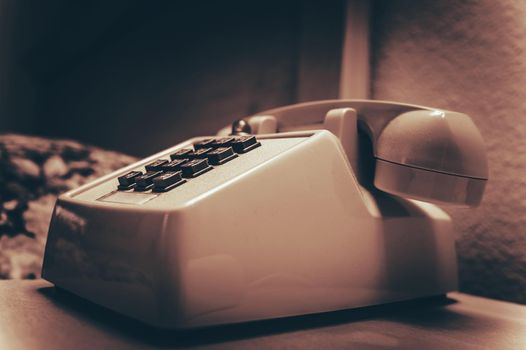Aged Vintage Desk Phone Features Tone Dial in Sepia Color Grading.