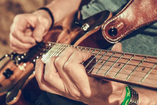 Caucasian Musician Playing Electric Guitar Close Up Photo. Music and Entertainment Industry Theme.