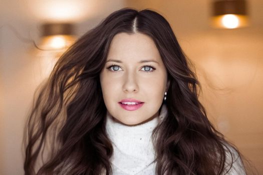 Winter portrait and Christmas holiday look. Beautiful woman in white sweater with long brown hair and glamour makeup, hairstyle model and xmas fashion.