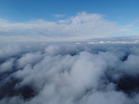 Camera is raising above from the thick fog above the beautiful ocean of clouds at sunrise. Sun is rising above the endless sea of clouds until the horizon. Amazing nature landscape, 4K drone in sky