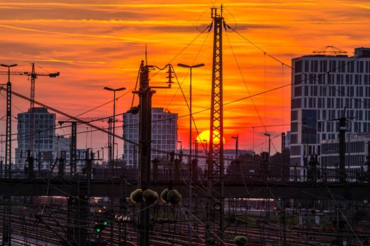 Munich at orange sunset, view over the railways towards the Donnersberger Bruecke.