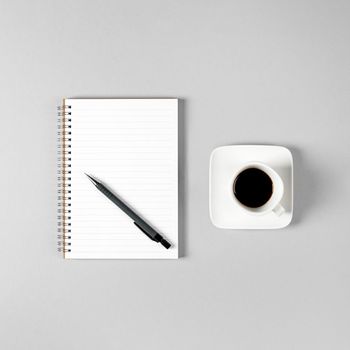 Notepad, pen and a cup of coffee isolated on light gray background. Notepad with copy space. Office, business, discreet style.