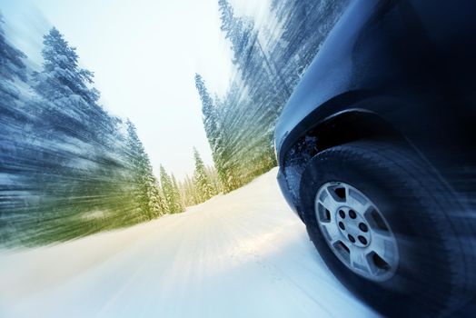 Speeding Car on Countryside Winter Road. Road Covered by Heavy Snow. Motion Blur.