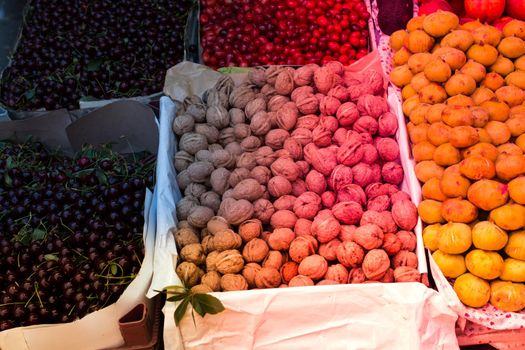 Shelled walnuts near cherries and figs on sale in a Turkish street bazaar