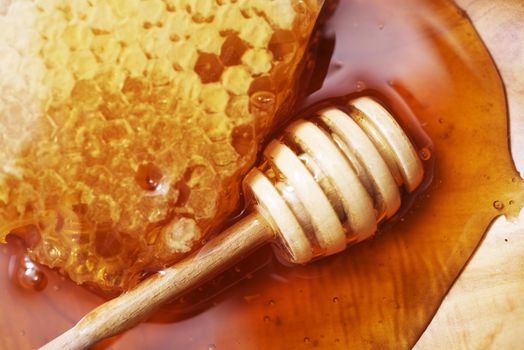 Honeycomb with Wooden Dipper on Wooden Plate Closeup