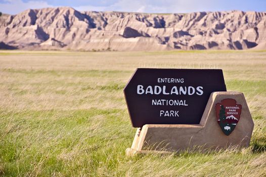 Badlands Entrance Sign. South Side Entrance. Prairie and Badlands in the Background. Badlands National Park, South Dakota, USA. National Park Service.