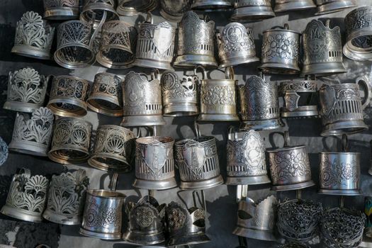 Silver mugs hanging from a wall on a sunny day