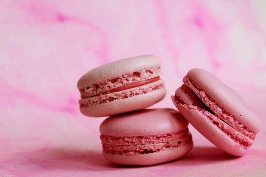 Three pink macaroon cakes on a pink background. Nice photo of food. Great ready-made design for calendar or other purposes. Desktop wallpaper.