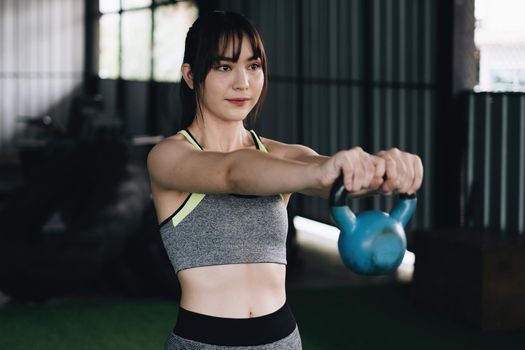 Woman in exercise gear workout with dumbbells during an exercise class at the gym. lifestyle and healthy, fitness, gym exercise, workout concept