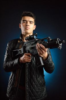 Asian guy in black jacket and automatic rifle