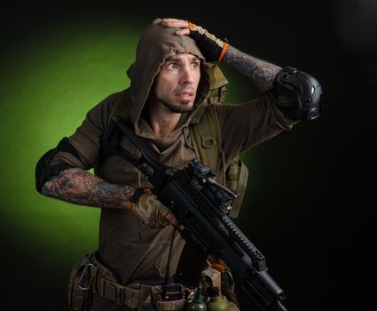 the man Stalker with a gun with an optical sight and a backpack on a dark background with emotions looking, aiming, watching, sneaking