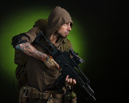 the man Stalker with a gun with an optical sight and a backpack on a dark background with emotions looking, aiming, watching, sneaking